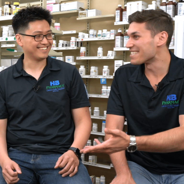 Two HB Pharmacy employees smiling while talking