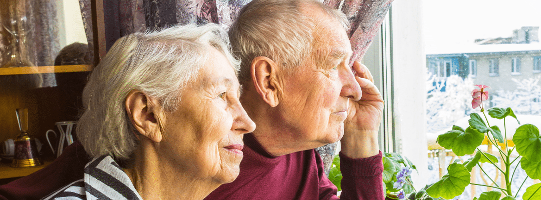 A senior couple looking out the window