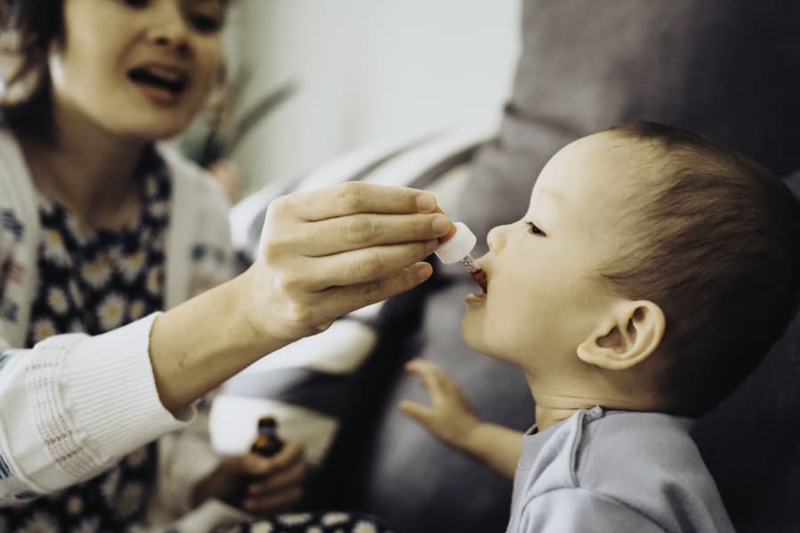 Child receives oral medication from parent